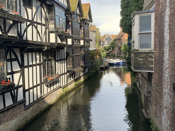 Canal amidst buildings against sky