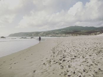 Man standing on beach against sky