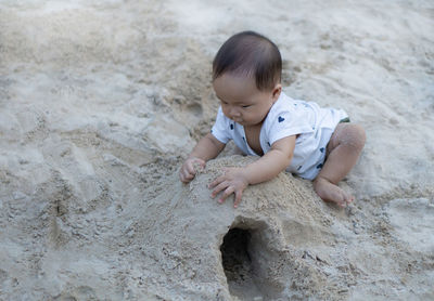 Cute baby girl making sandcastle at beach