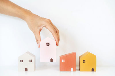 Close-up of hand with toy against white background