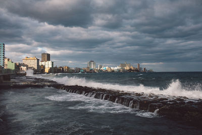 Scenic view of sea by buildings against sky