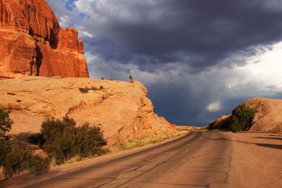 Road amidst rock formation against sky