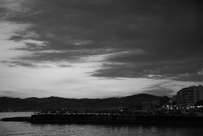 Scenic view of river by mountains against sky