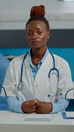 Portrait of young doctor examining patient at clinic