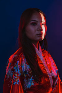 Young woman standing against black background