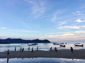 People on beach against blue sky