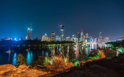 Illuminated buildings against sky at night