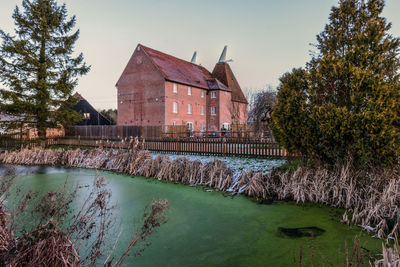 Scenic view of lake by buildings against sky