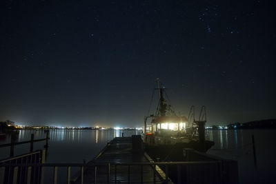 Scenic view of sailing boat in sea against sky at night