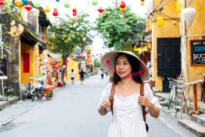 Portrait of young woman standing in city