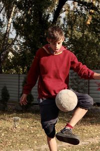 A boy plays with a soccer ball in the yard at the weekend