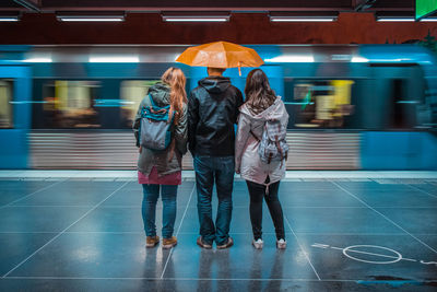 Rear view of women walking on subway station