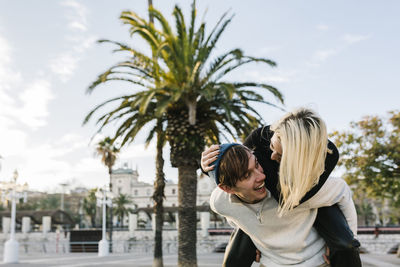 Woman with palm tree against sky