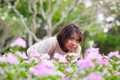 Close-up of young woman standing amidst flowers