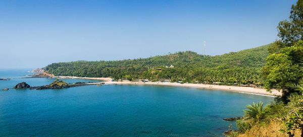 Scenic view of sea and mountains against blue sky