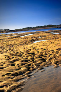 Scenic view of beach against clear blue sky