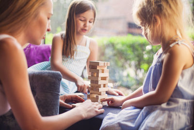 Girls playing with wooden blocks at home