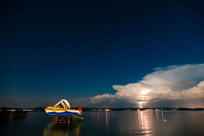 Boat in sea against sky at night