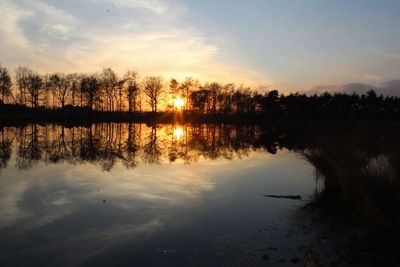 Reflection of trees in lake during sunset