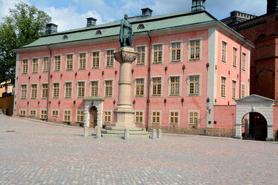 Houses by street against sky in city