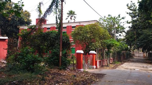 Red built structure by trees against sky