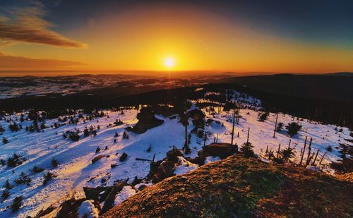 Scenic view of snowcapped mountains against sky during sunset