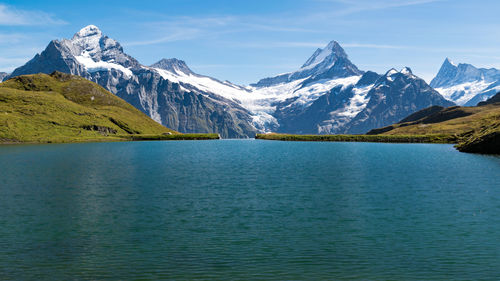 Scenic view of lake and snowcapped mountains against sky