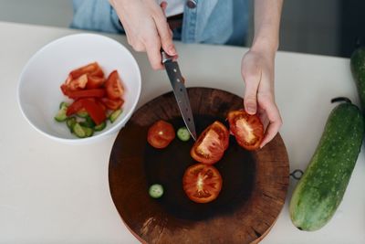 Cropped hand of person preparing food on table