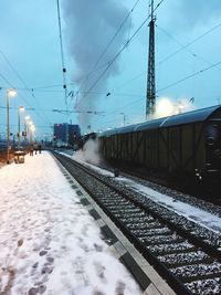 Railroad tracks against sky during winter