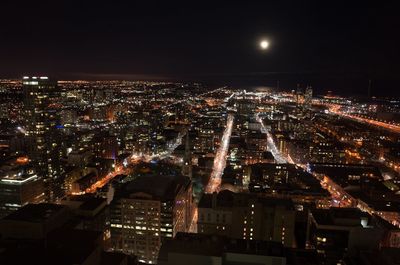 Illuminated cityscape against sky at night