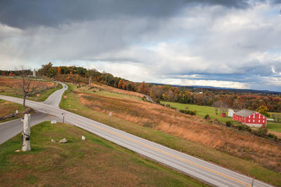 Road amidst field against sky