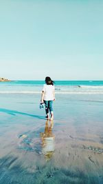 Full length of boy standing on beach against sky