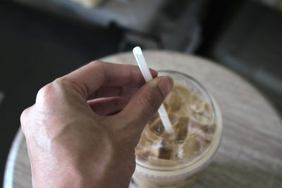 Close-up of hand having drink at table