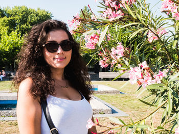Portrait of smiling woman with sunglasses against plants