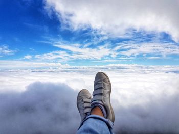 Low section of man against cloudscape