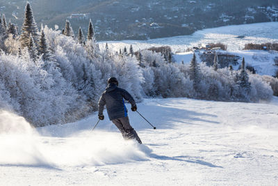 Man skiing on snowcapped mountains during winter