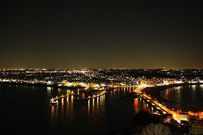 Illuminated city against sky at night