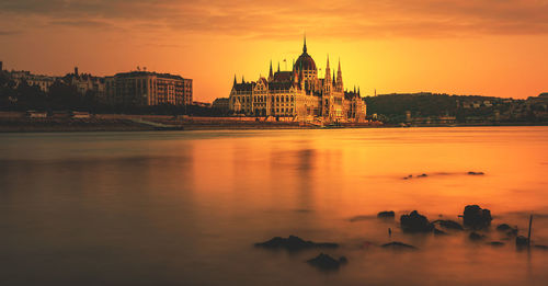 View of buildings at waterfront during sunset
