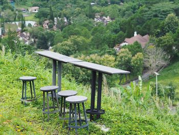 Empty chairs and table on field