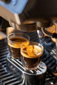 Two glasses of freshly brewed espresso coffee with crema made by an espresso machine