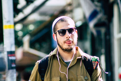 Portrait of young man wearing sunglasses standing outdoors