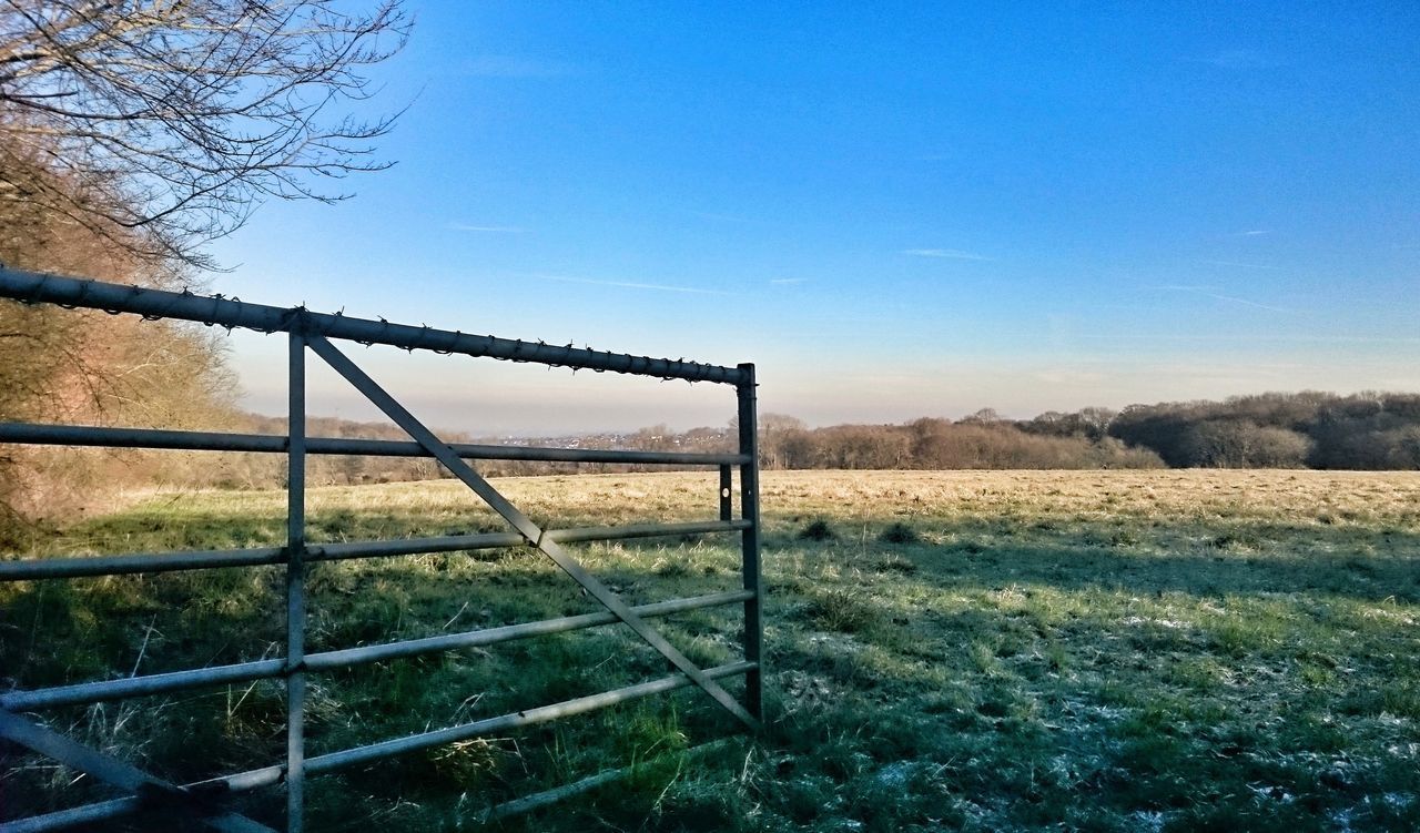 FENCE ON FIELD AGAINST CLEAR BLUE SKY