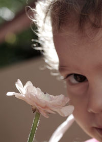 Close-up portrait of girl with pink flower