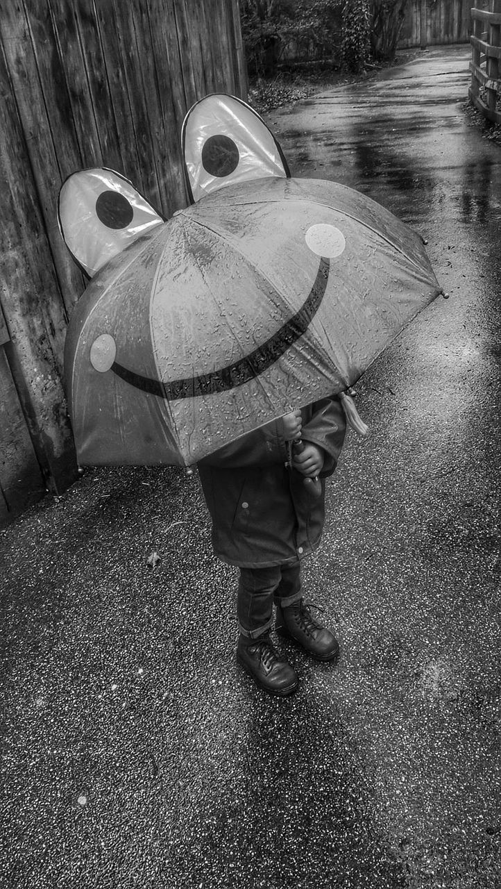 REAR VIEW OF MAN WITH UMBRELLA