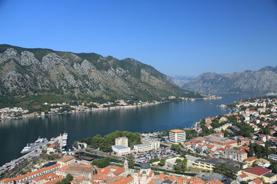 Scenic view of lake and mountains against clear blue sky