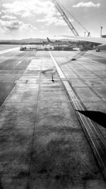 View of airplane flying over runway against sky