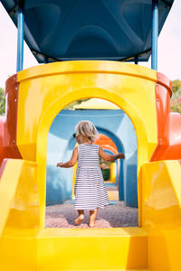 Rear view of woman standing in playground