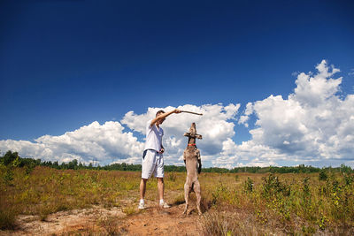 Woman standing on field against sky