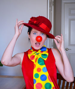 Portrait of woman wearing costume and clown at home