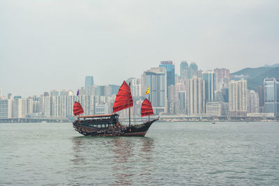 Boat in sea against cityscape